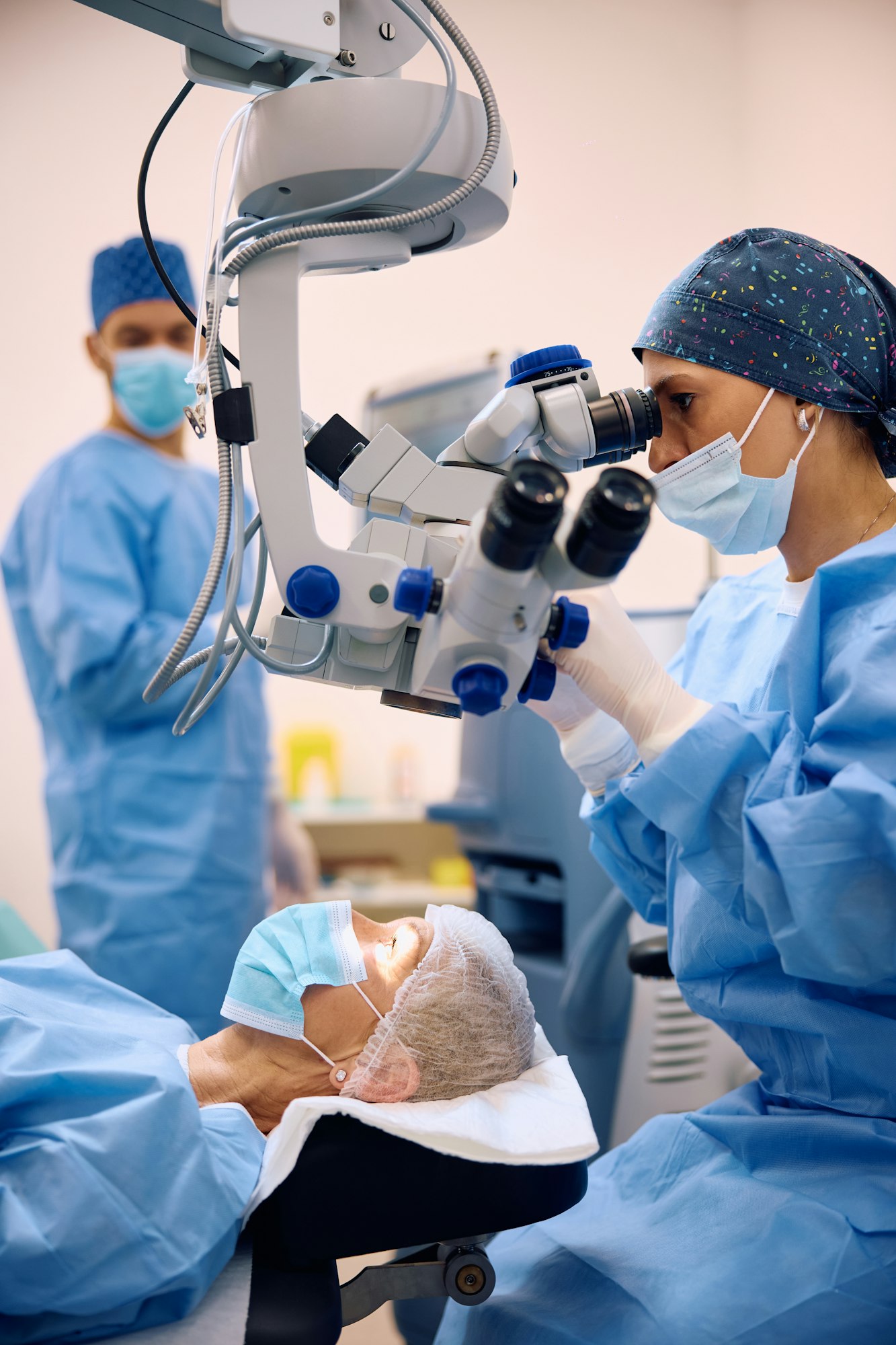 Medical expert using microscope while performing eye surgery at ophthalmology clinic.